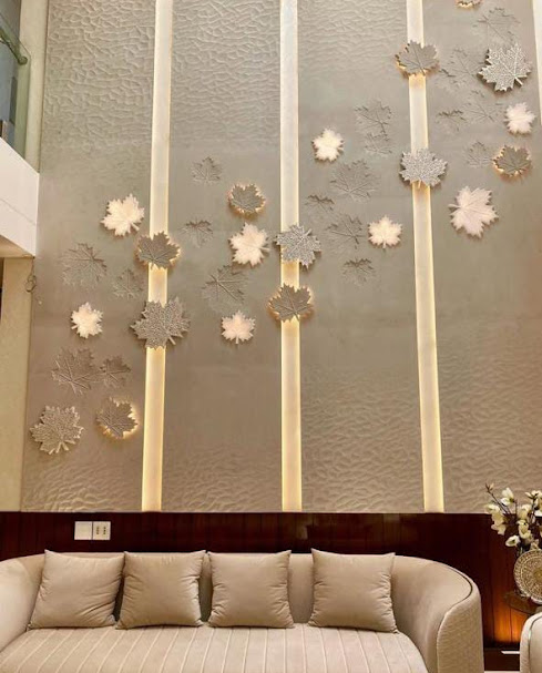 Luxury double-height living room featuring an expansive floor-to-ceiling CNC carved natural stone accent wall by Stone World